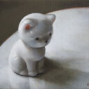 陶でできた白い猫の像がおすわりをしている様子が描かれている。